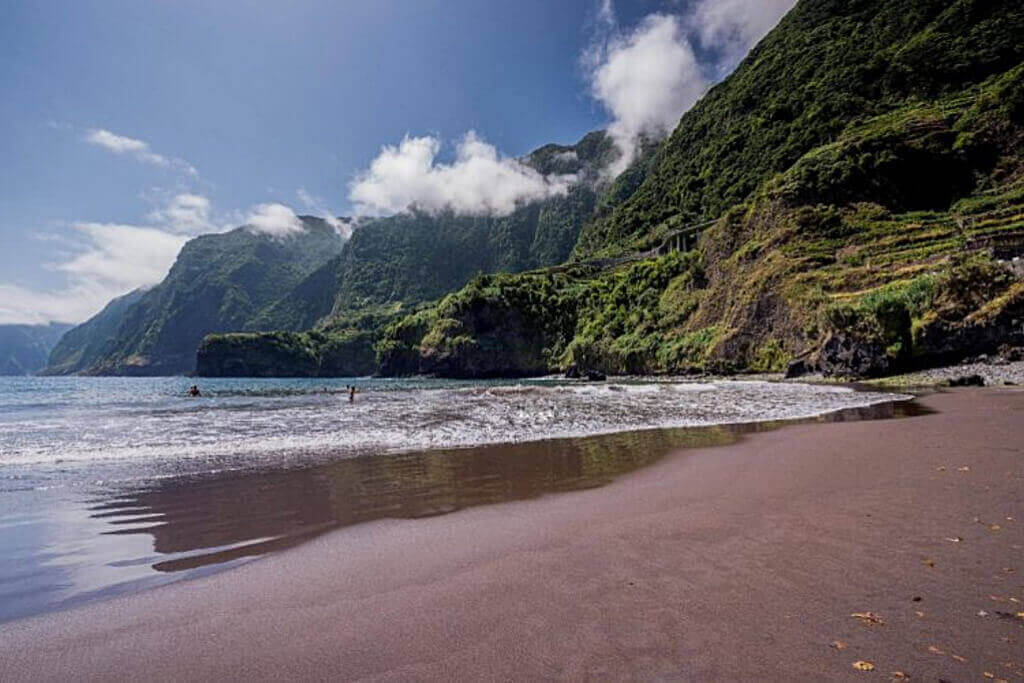 Praia de areia natural preta do Seixal na vertente norte da Ilha da Madeira com vista para as montanhas